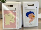 two boxes with drawings on them sitting on a table next to a laptop
