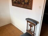 a chair in the corner of a room with a painting on the wall
