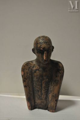 une petite statue représentant un homme assis sur une table