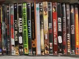 a lot of dvd ' s stacked on a shelf together