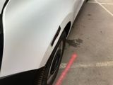 a white car parked in a parking lot next to a building