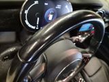 a steering wheel and dashboard of a car with a clock on it