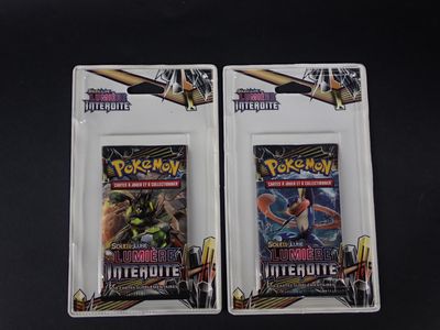 deux paquets de cartes à collectionner Pokémon posés sur une surface noire