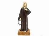figurine représentant une femme tenant un chapelet, posée sur un socle en bois