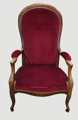 une chaise rouge avec une structure en bois et un revêtement en velours rouge
