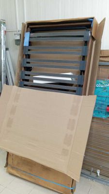 un grand carton posé par terre à côté d'une pile de cartons