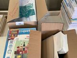 de nombreuses caisses de livres posées sur un bureau encombré de papiers