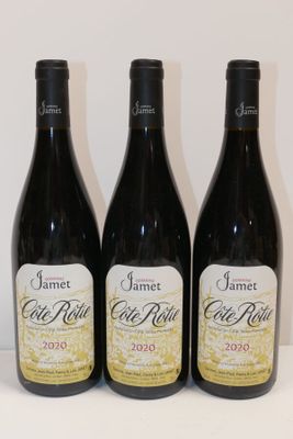 three bottles of red wine sit on a white table