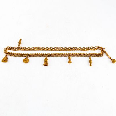 un gros plan sur un bracelet en or orné de clochettes