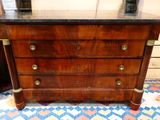 a wooden chest of drawers with a marble top