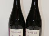deux bouteilles de vin posées sur une table l'une à côté de l'autre