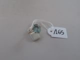une image représentant une bague sertie d'une topaze bleue sur un fil