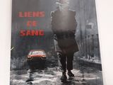 La couverture du livre *Liens de sang* est posée sur une table