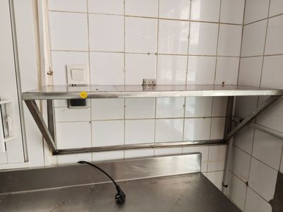 a stainless steel counter in a kitchen with tile on the walls