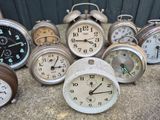 a lot of clocks sitting on the ground next to each other