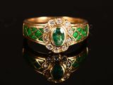 a close up of a gold ring with a green stone