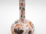 un vase blanc orné de fleurs orange et bleues