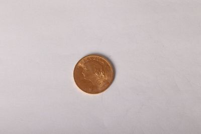 a close up of a penny sitting on top of a white surface