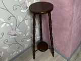 une petite table avec un tabouret devant un mur rose