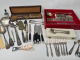 a lot of silverware on a table with a red box