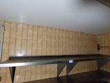 une étagère métallique au milieu d'un mur carrelé
