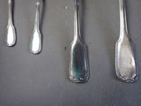 five spoons and a fork hanging on a wall