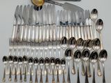 a lot of silver spoons and silverware on the table