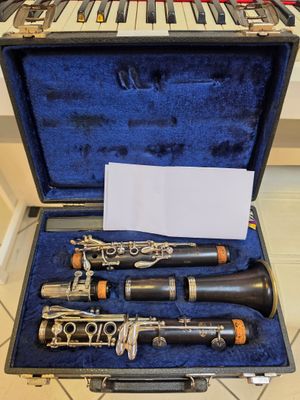two clarinets in a case sitting on a tile floor