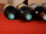 several bottles of wine are lined up on a red table