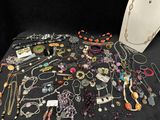 a lot of necklaces and bracelets on a table