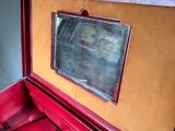 a red suitcase with a mirror in it sitting on a table