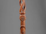 an image of a wooden sculpture of a person with a cane