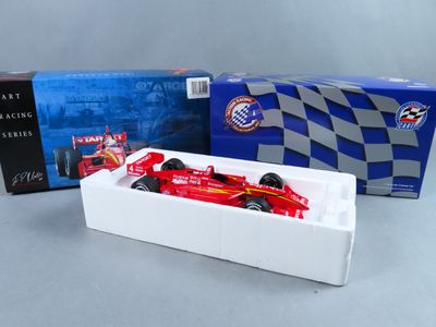 une voiture de course rouge dans une boîte blanche à côté d'une boîte bleue