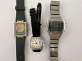 three different watches sitting next to each other on a white surface