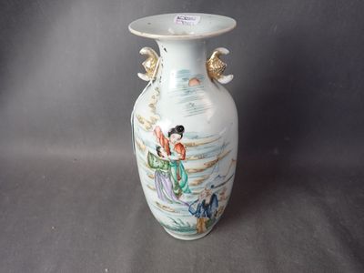 un vase blanc avec un tableau posé sur une table