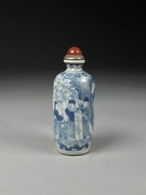 un petit vase bleu et blanc avec un couvercle rouge