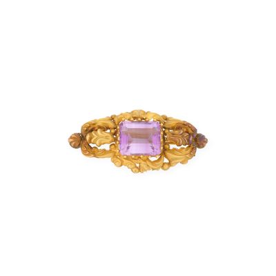 a close up of a gold ring with a pink stone