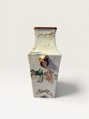 a white vase with a handle on it on a white surface