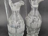 two clear glass vases sitting next to each other on a table