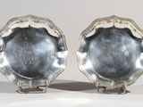pair of silver plated dishes on stands on a white surface