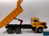 a toy truck with a yellow dump truck on the back of it