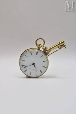 a gold pocket watch with a key attached to it