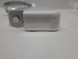 a white power adapter sitting on a table next to a cell phone