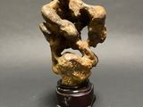 an image of a sculpture of two hands holding a rock
