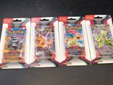 three packs of pokemon trading cards sitting on top of a table