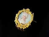 a gold plated broochle with a portrait of a woman