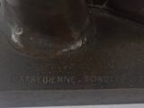 bronze statue of a man ' s shoes on a black base