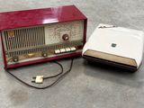 une radio rouge posée par terre à côté d'un ordinateur portable