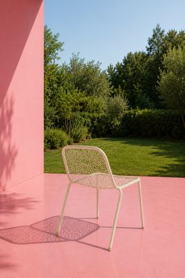 une chaise posée sur un sol rose