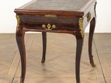 a small wooden table with a marble top on a wooden floor